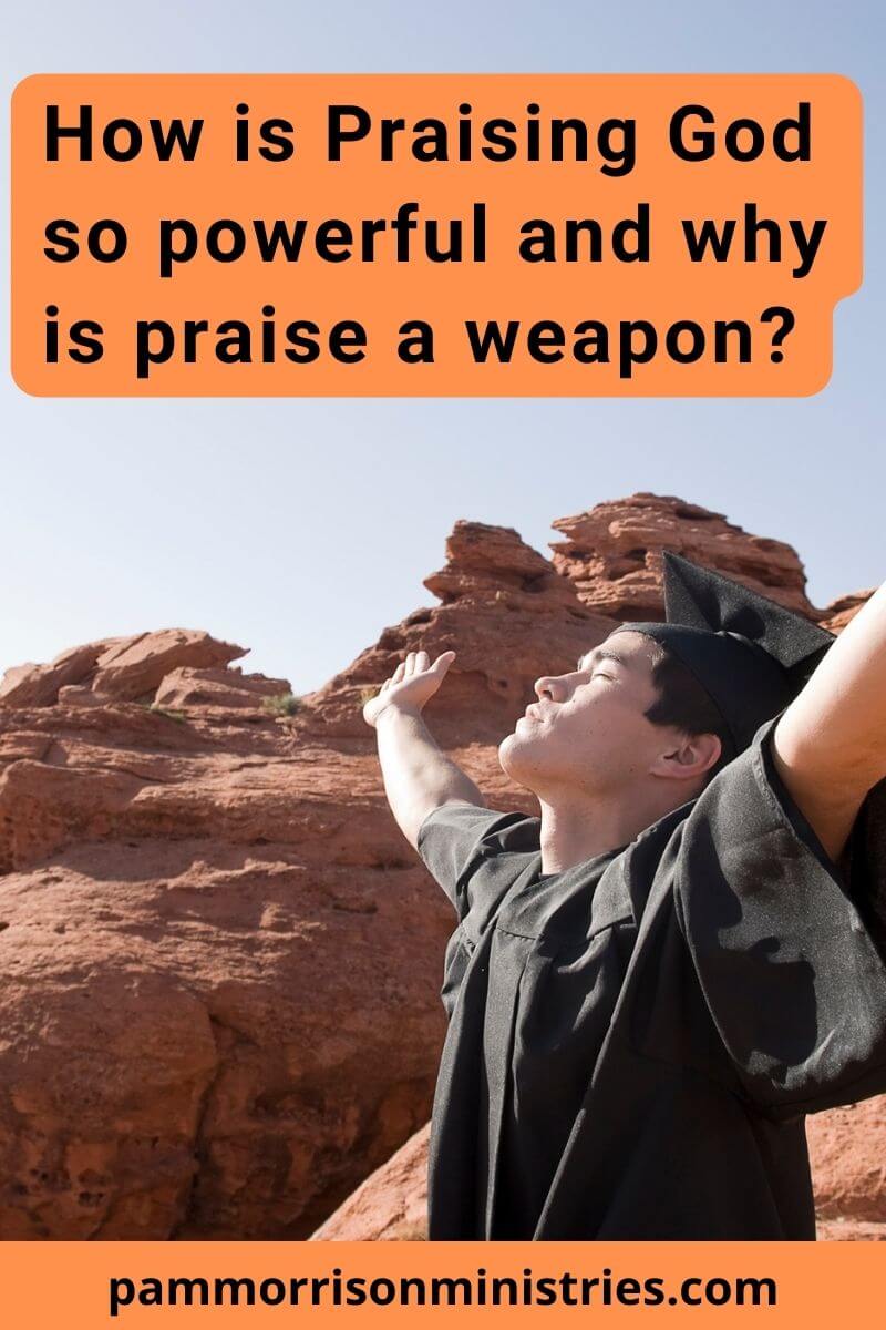 man raising arms outdoors as he worships