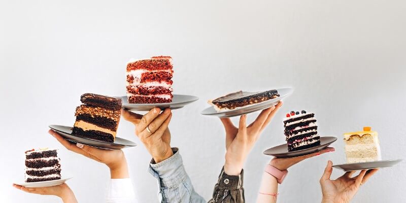 pieces of cake held up by hands